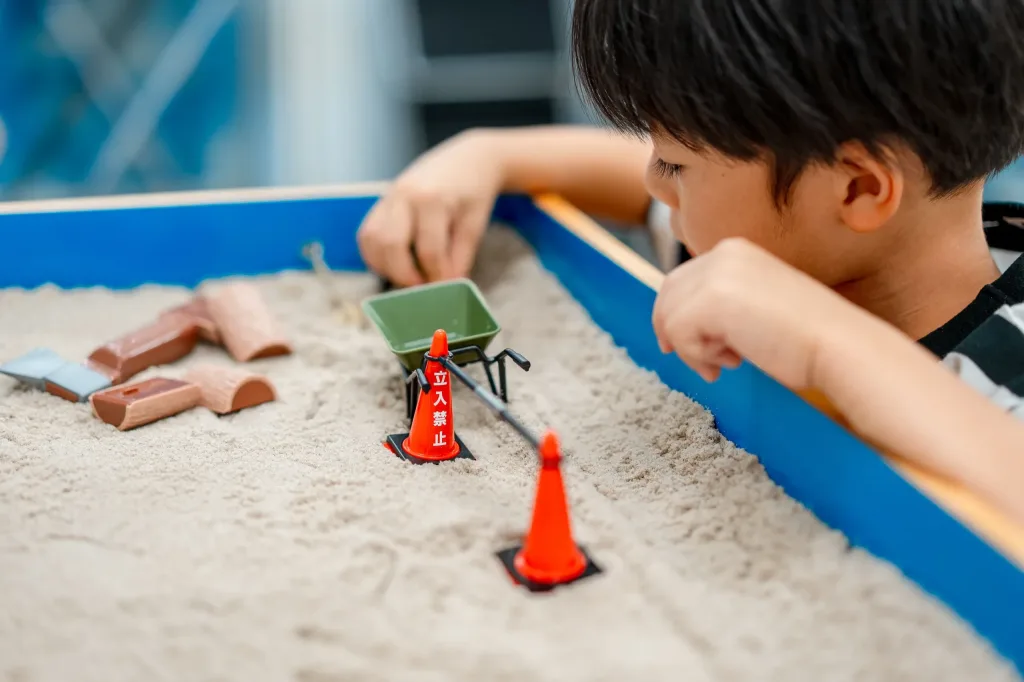 お子さまが遊びを通じて心理検査を受けている様子。砂場療法のセッション風景